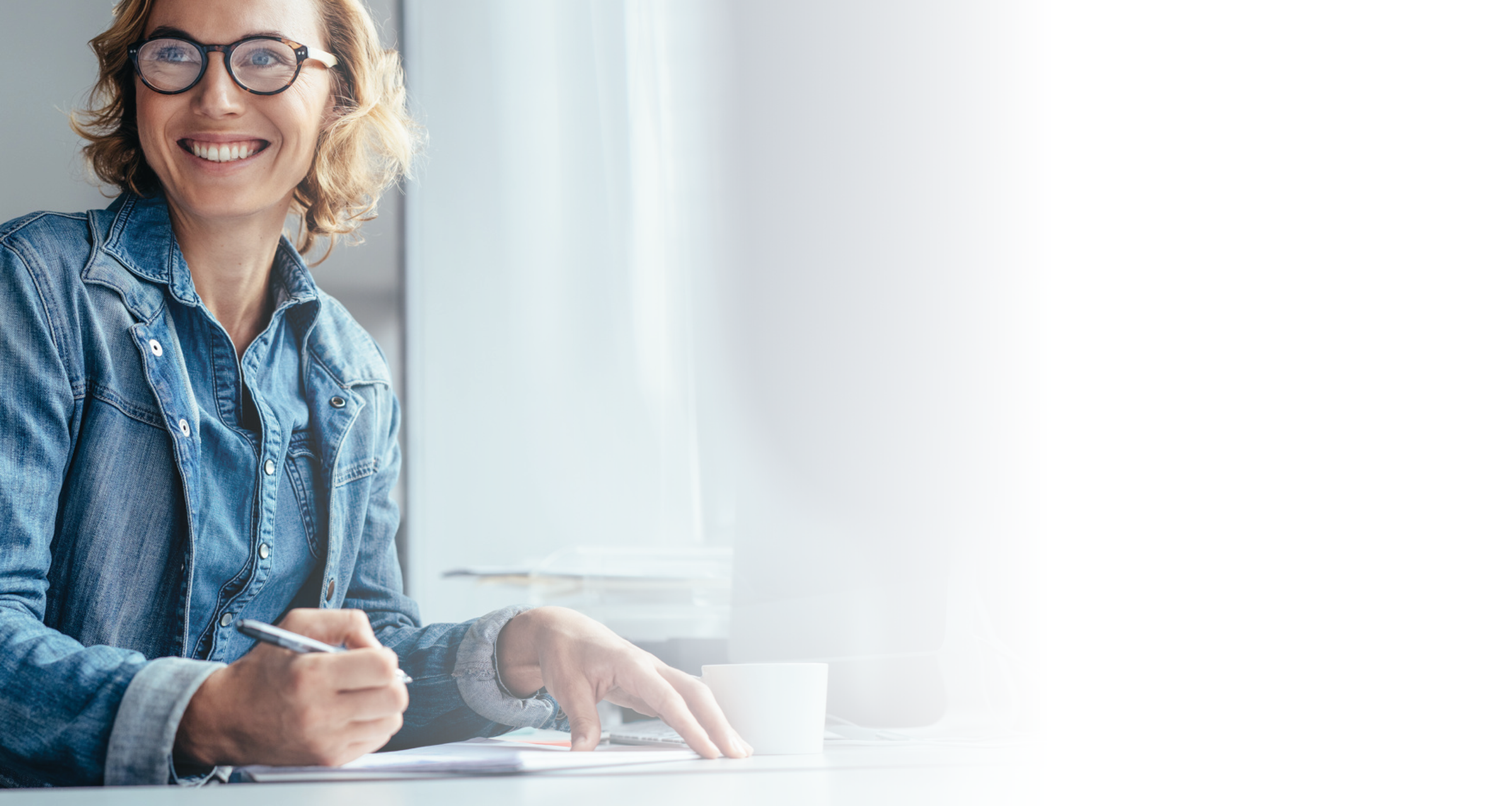 Young businesswoman sitting in office looking away and smiling